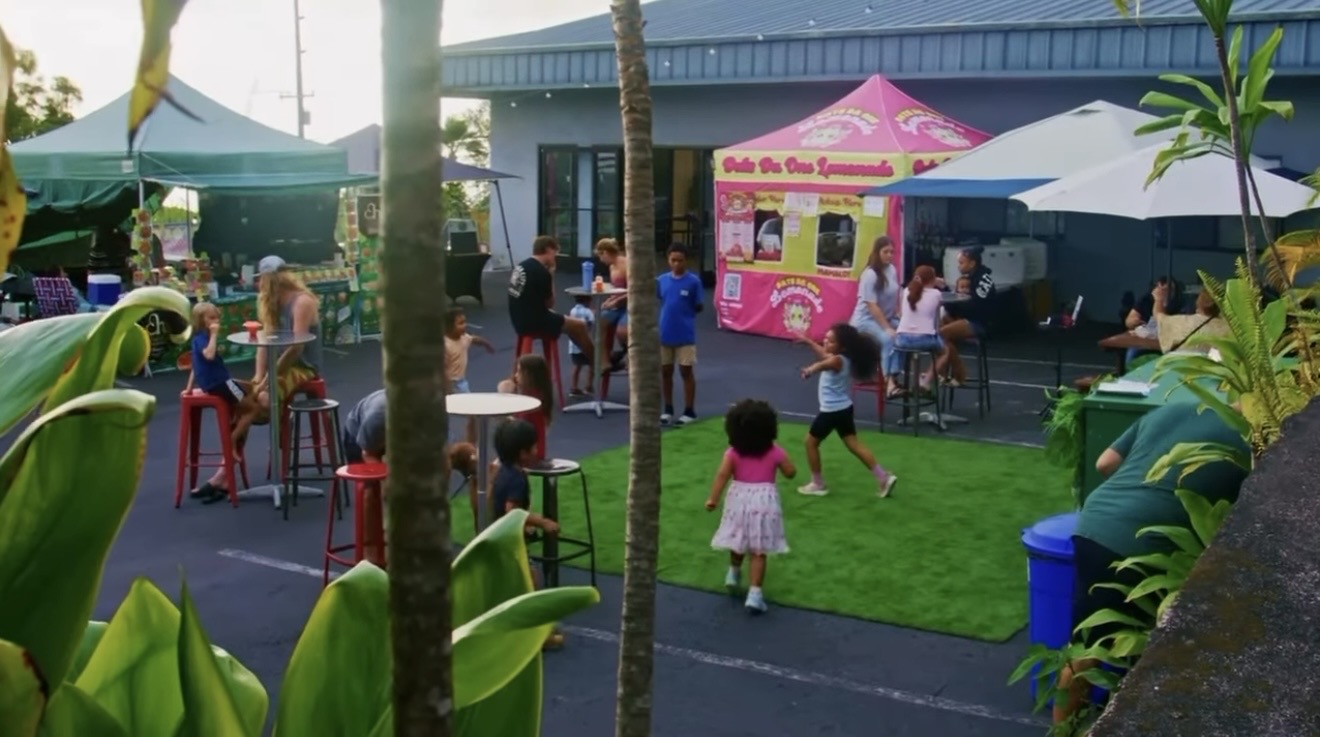 Families gathering on the turf yard at The Source market